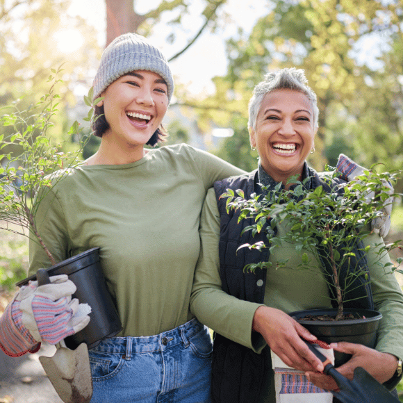 Two people holding plants.