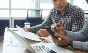 Two people looking at a calculator