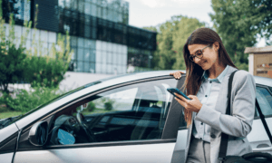 Someone standing by a car who is on their phone