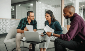 Three people looking at reports