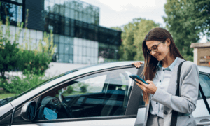 Someone standing by a car who is on their phone