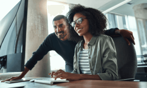 Two people looking at a computer.