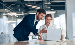 Two people looking at a laptop.