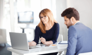 Two people looking at a laptop.