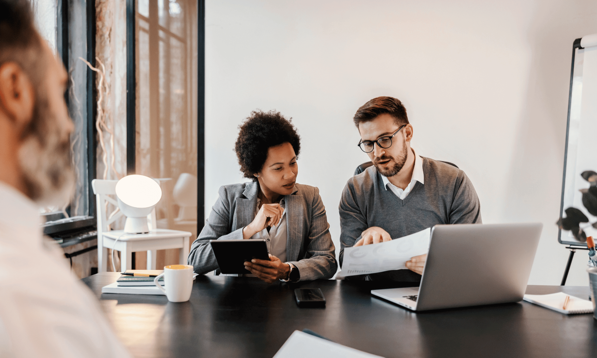 Two people looking a paper with charts.