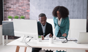 People looking at papers on a desk.