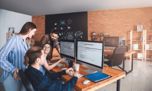 Four people looking at computer code.