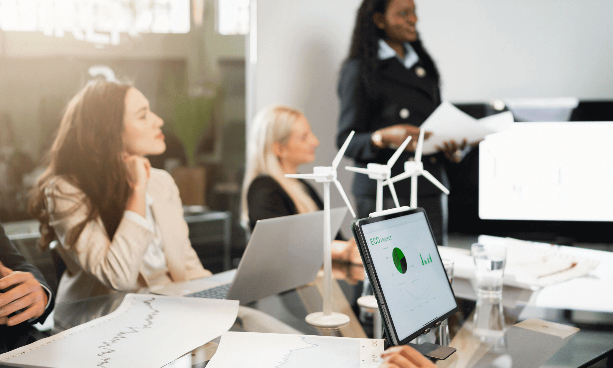 People in a meeting with windmills on a table.