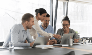 Four people looking at a laptop.