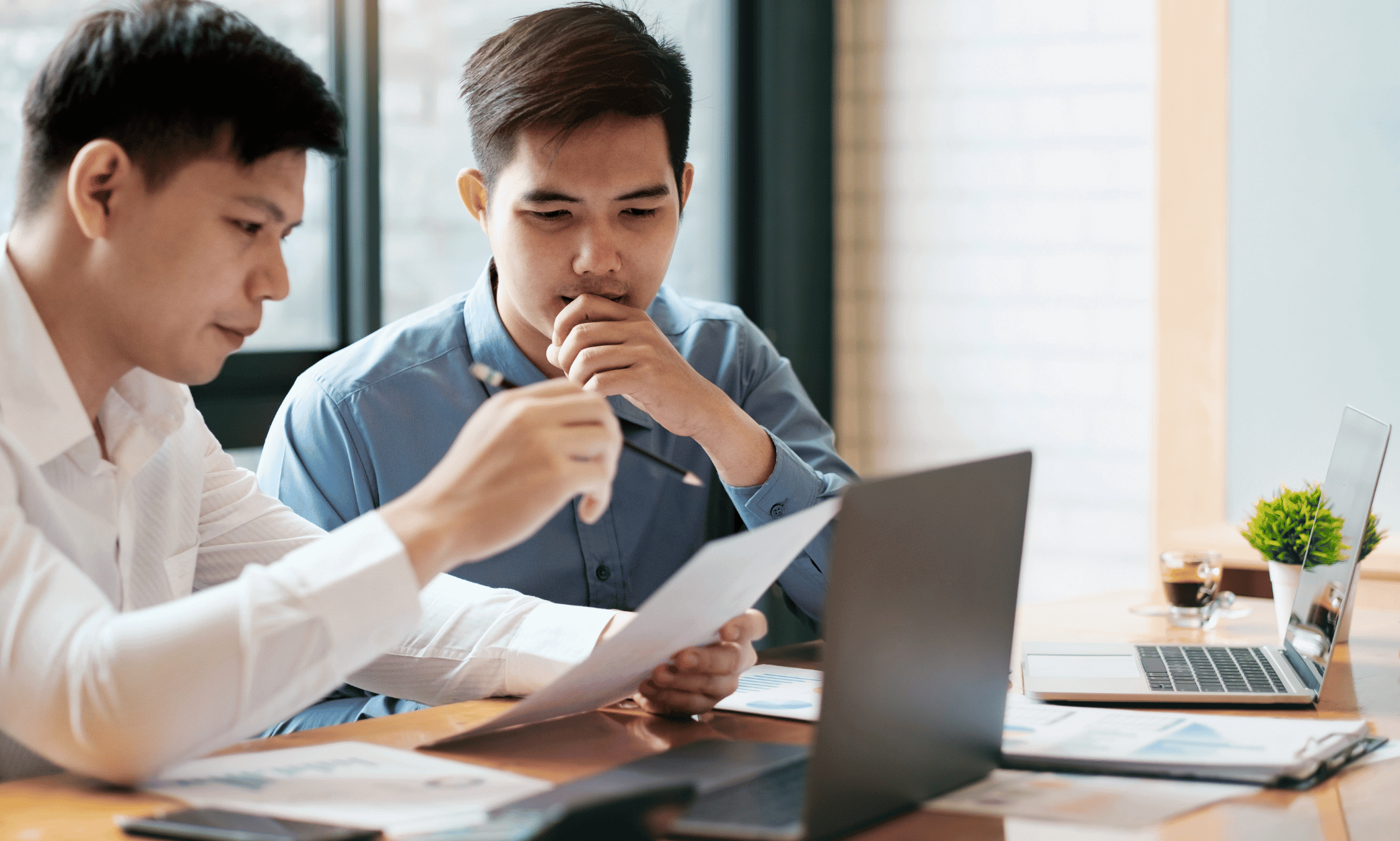 Two people looking at a piece of paper.