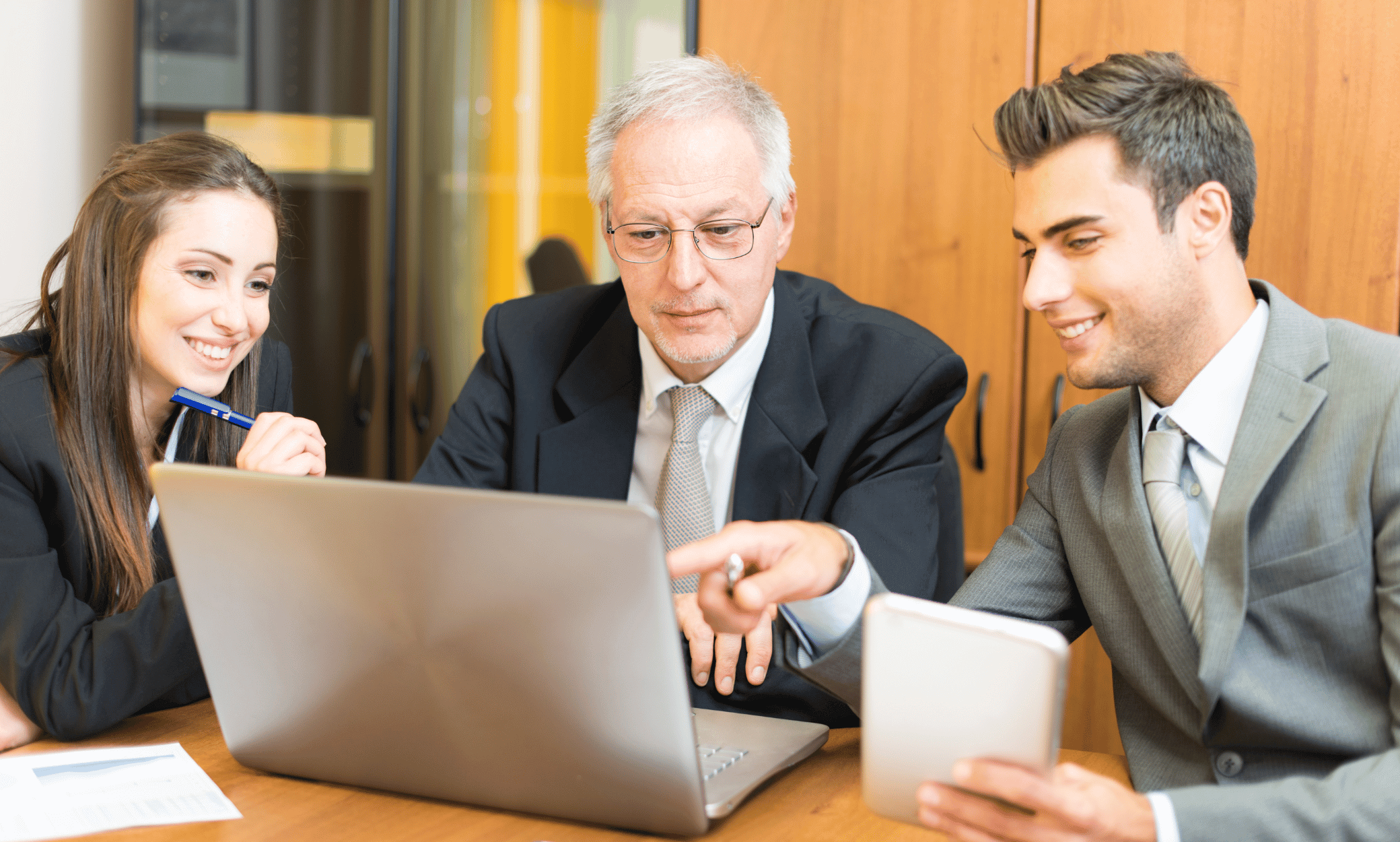 Three people looking at a computer.