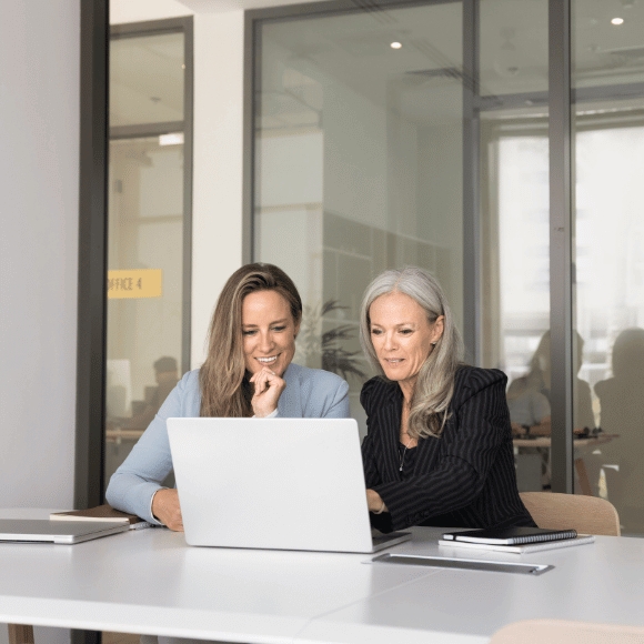 Two people looking at a laptop.