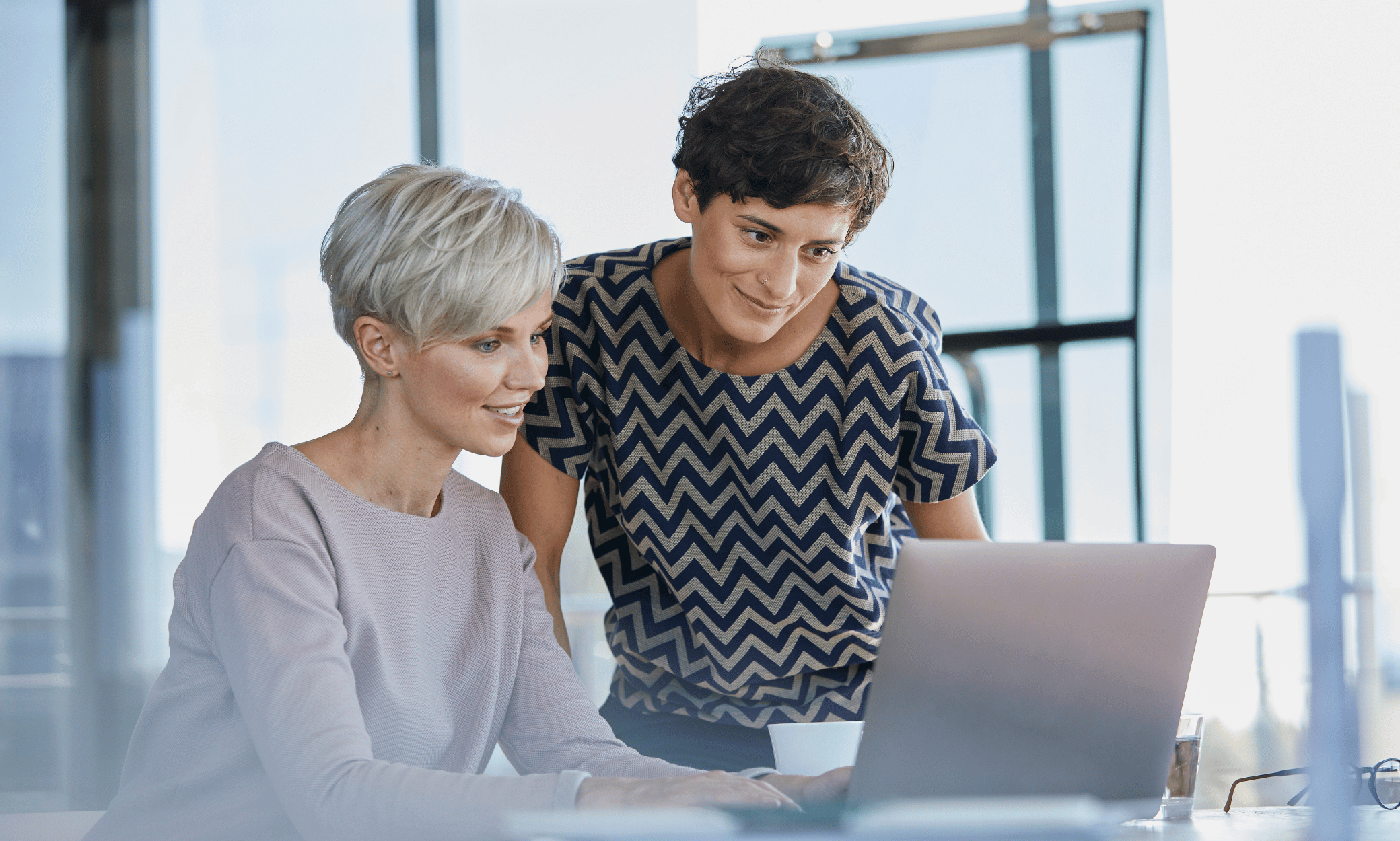 Two people looking at a laptop.