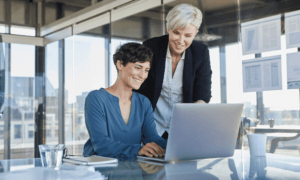 Two people looking at a laptop.