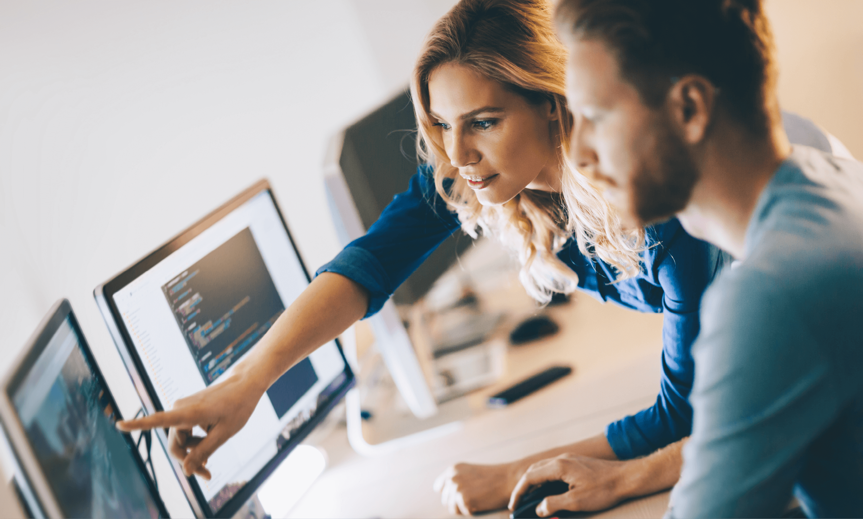 Two professionals looking at computer software on screen