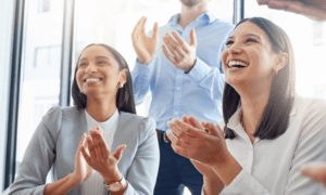 Three workers smiling and celebrating an accomplishment.