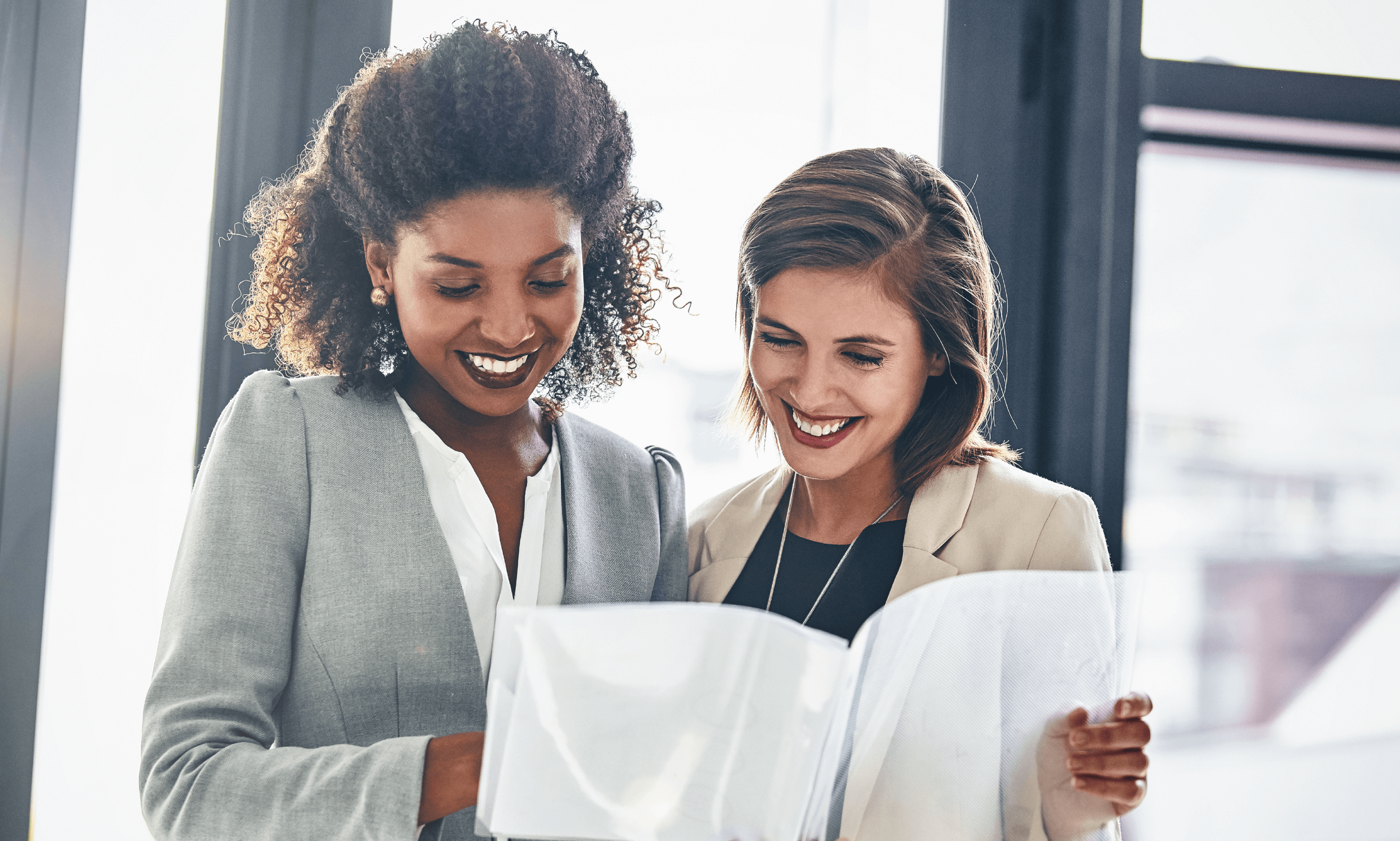 Two people smiling at a paper.