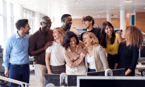 People standing around a computer and laughing