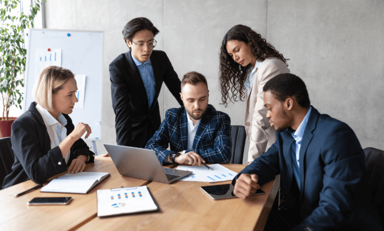 Group of people analyzing and discussing documents and reports.