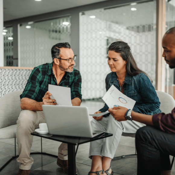 Three people looking at papers.