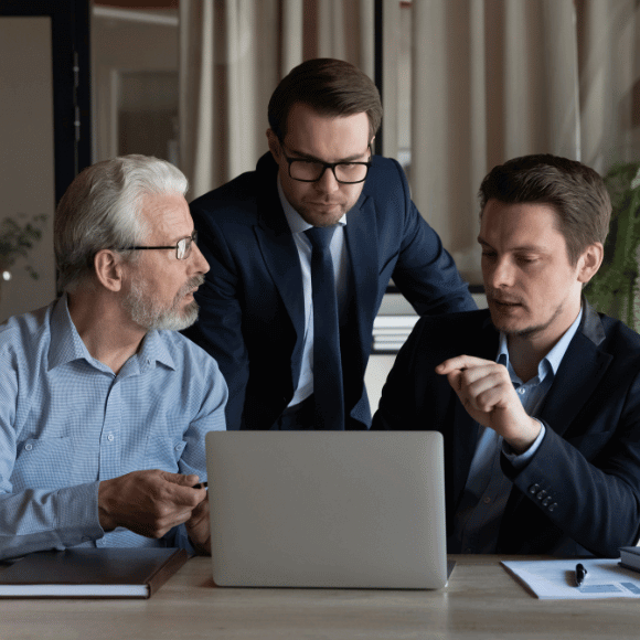 Three people looking at a computer.