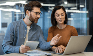 Two people looking at a laptop and collaborating.