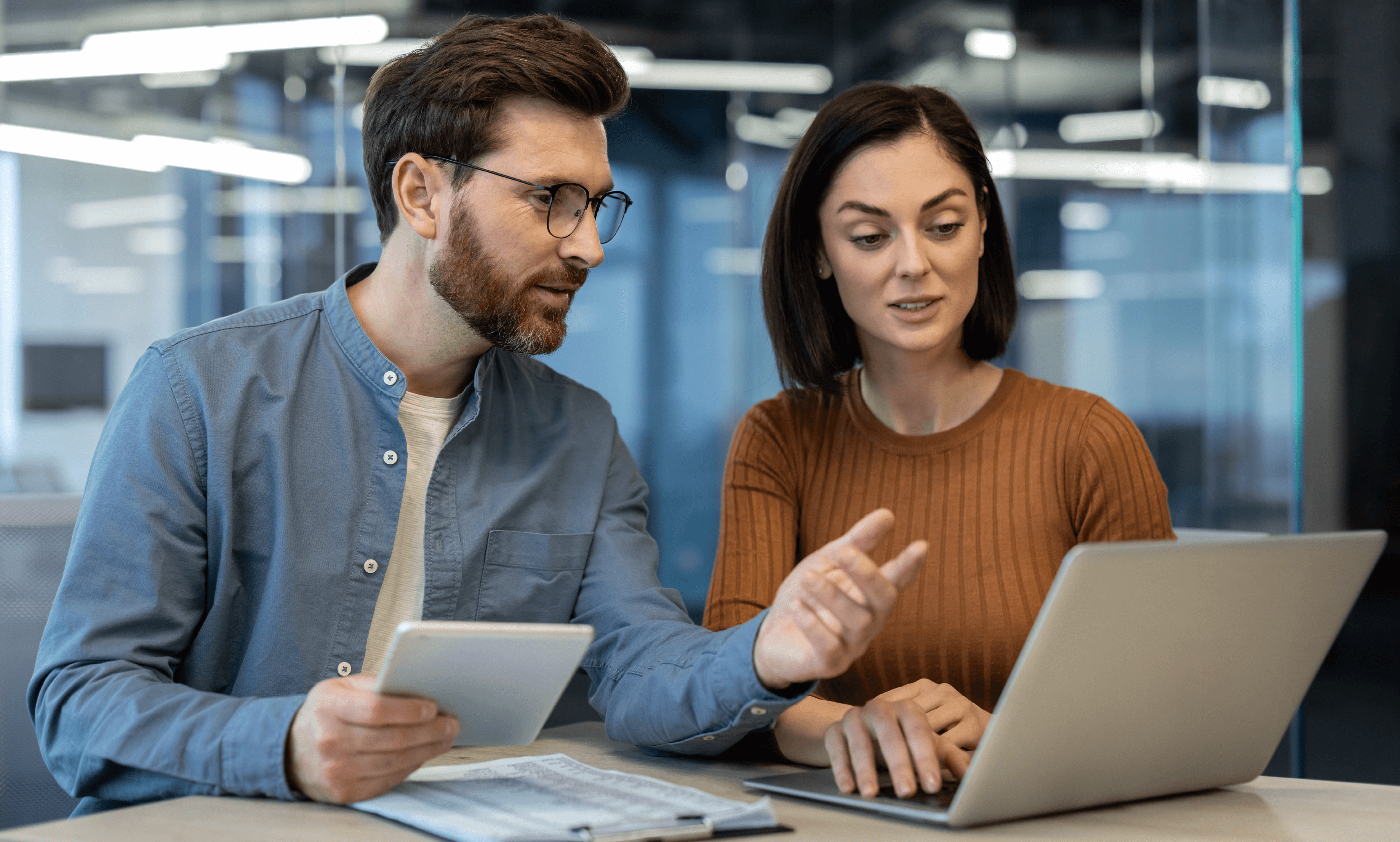 Two people looking at a laptop and collaborating.