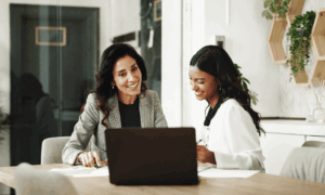 Two people looking at a laptop.
