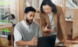 two people looking at a laptop