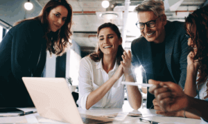 Four people looking at a laptop