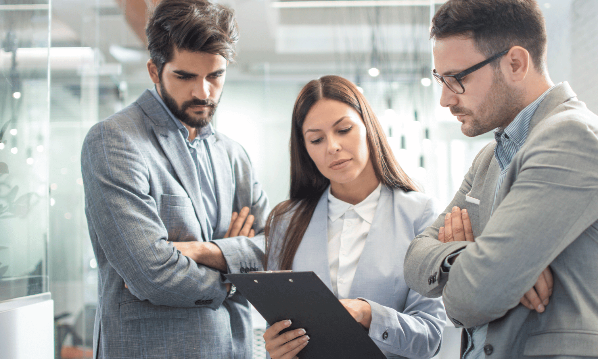 Three people looking at a clipboard