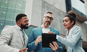 Three people looking at a tablet