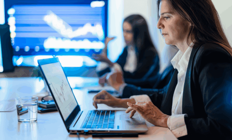 Two people looking at computers and their work.