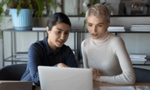 two people looking at a laptop and discussing.