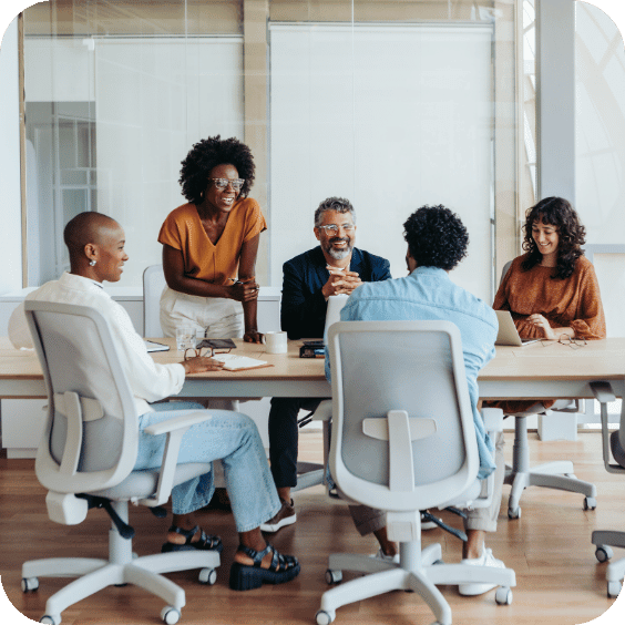 People in an office sitting and standing around a table
