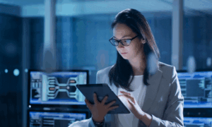 Person with glasses looking at a tablet.
