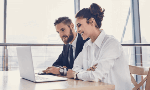 Two people looking at a laptop.