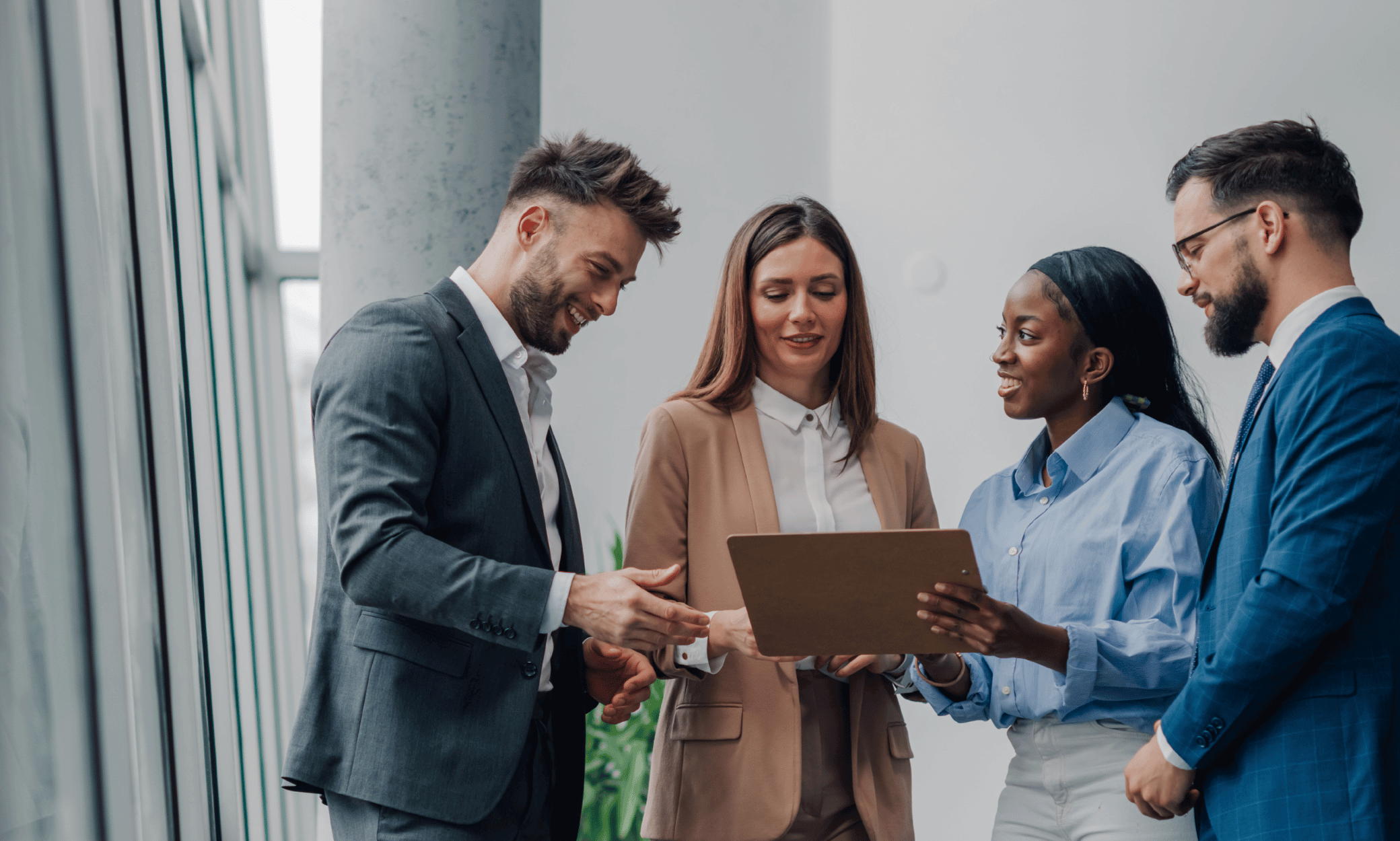 Four people looking at a tablet.