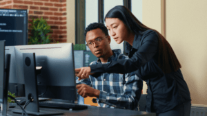 Two people looking at a computer.